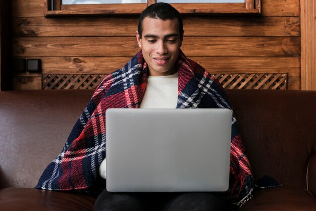Retrato de hombre guapo con una computadora portátil