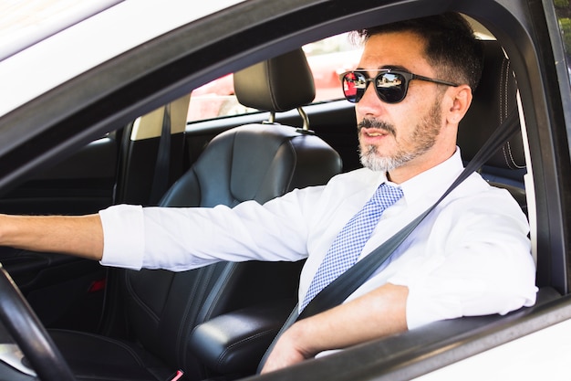 Retrato de hombre guapo conduciendo el coche