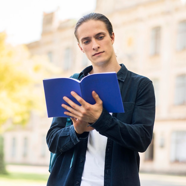 Foto gratuita retrato de hombre guapo estudiando en el campus