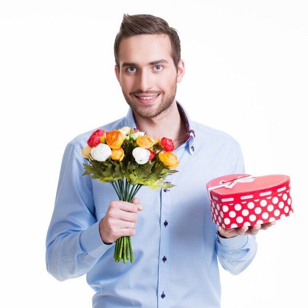 Retrato de hombre guapo feliz con flores y un regalo - aislado en blanco.