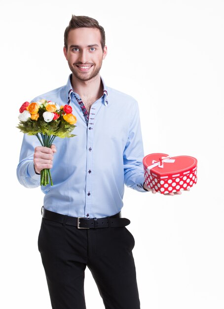 Foto gratuita retrato de hombre guapo feliz con flores y un regalo - aislado en blanco