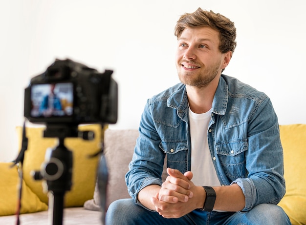 Retrato de hombre guapo grabando a sí mismo en casa