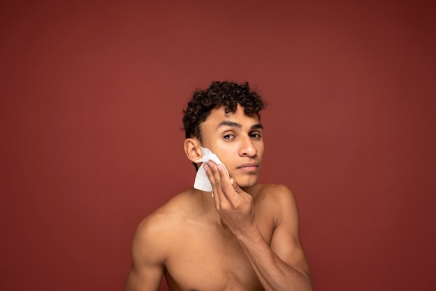 Retrato de un hombre guapo limpiando su rostro con un pañuelo