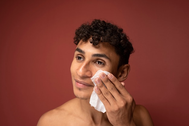 Retrato de un hombre guapo limpiando su rostro con un pañuelo