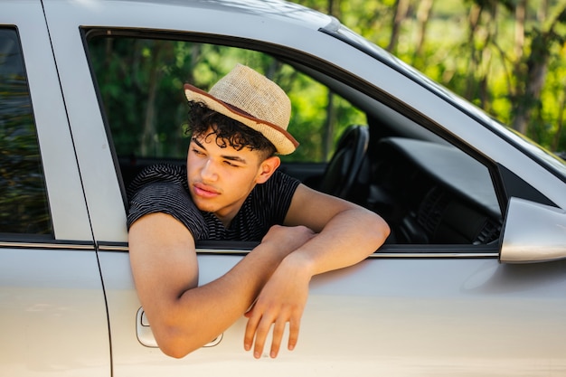 Foto gratuita retrato de hombre guapo mirando lejos de la ventana del coche