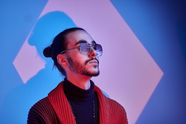 Retrato de hombre guapo de moda con gafas de sol en el estudio fotográfico.