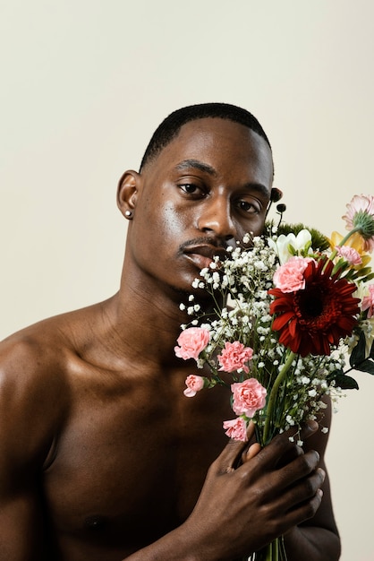 Retrato de hombre guapo posando con ramo de flores