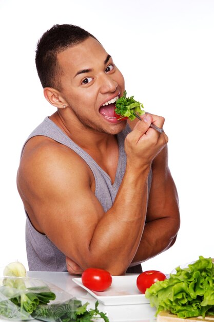 Retrato de hombre guapo posando sobre fondo blanco con comida