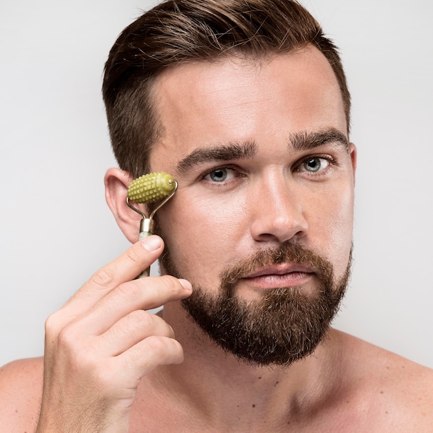 Retrato de hombre guapo con un rodillo facial