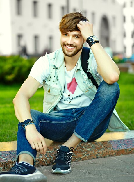 Retrato de hombre guapo en ropa con estilo hipster. Chico atractivo posando en la calle