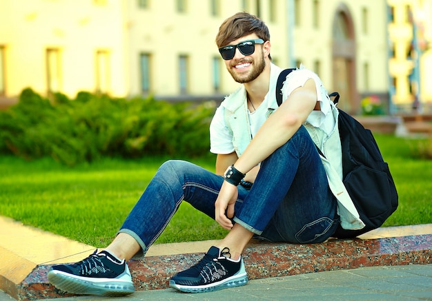 Retrato de hombre guapo en ropa con estilo hipster. Chico atractivo posando en la calle