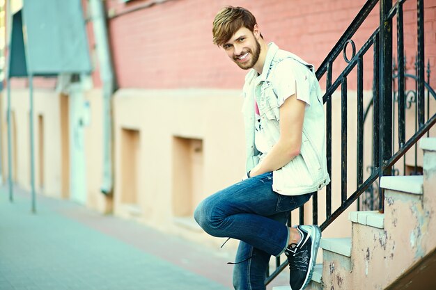 Retrato de hombre guapo en ropa con estilo hipster. Chico atractivo posando en la calle