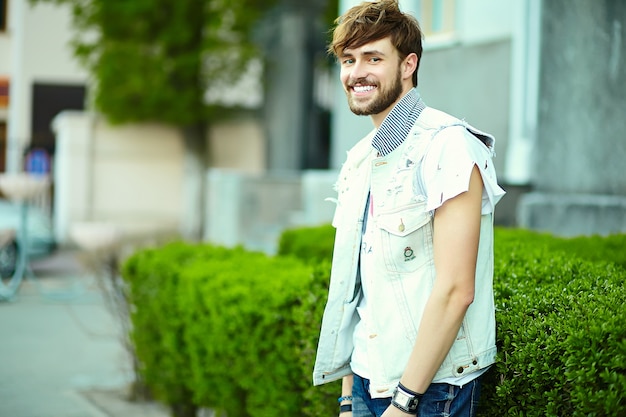 Retrato de hombre guapo en ropa con estilo hipster. Chico atractivo posando en la calle