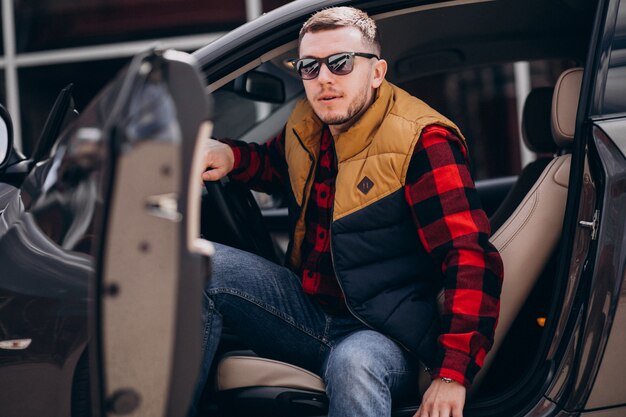 Retrato de hombre guapo sentado en el coche