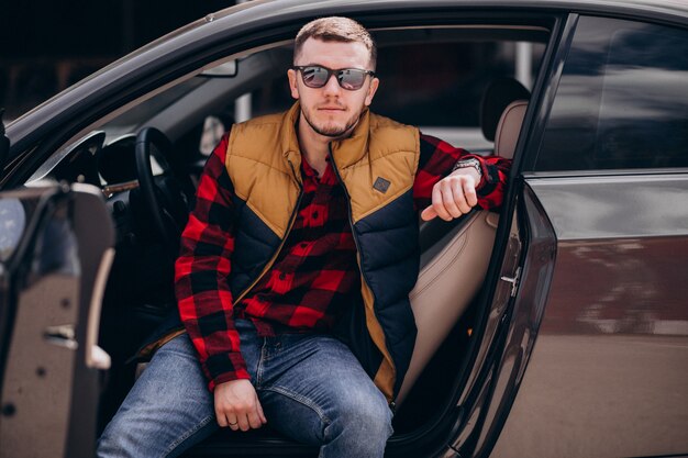 Retrato de hombre guapo sentado en el coche