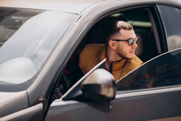 Retrato de hombre guapo sentado en el coche