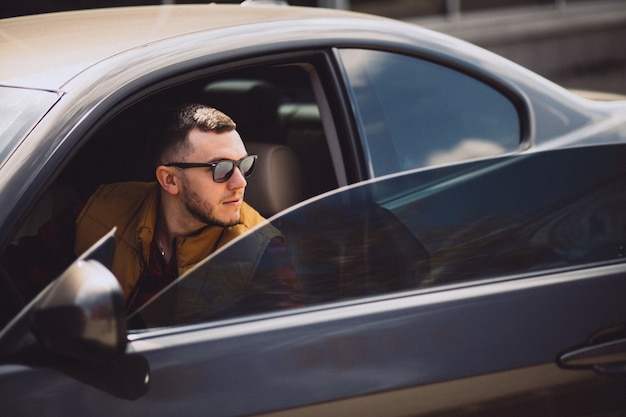 Retrato de hombre guapo sentado en el coche