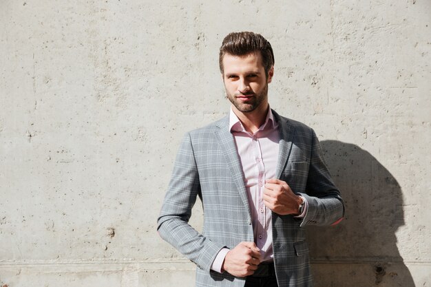 Retrato de un hombre guapo serio en una chaqueta de pie