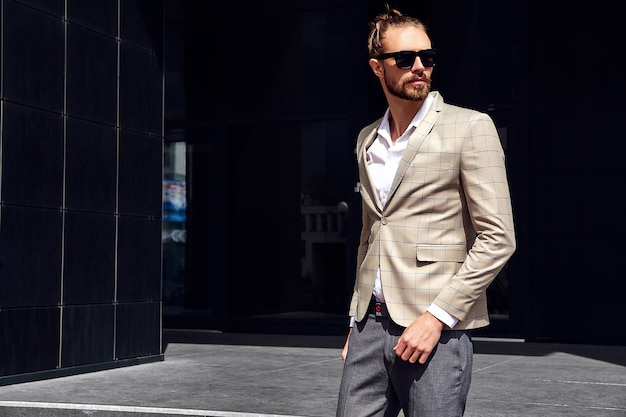 Retrato de hombre guapo sexy vestido con elegante traje a cuadros beige