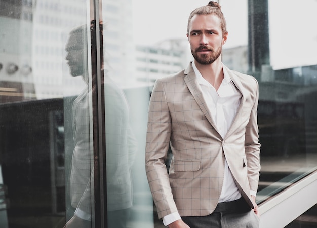 Retrato de hombre guapo sexy vestido con elegante traje a cuadros beige