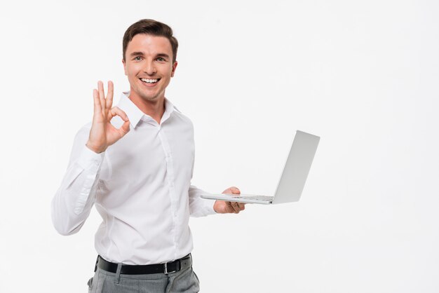 Retrato de un hombre guapo sonriente con laptop