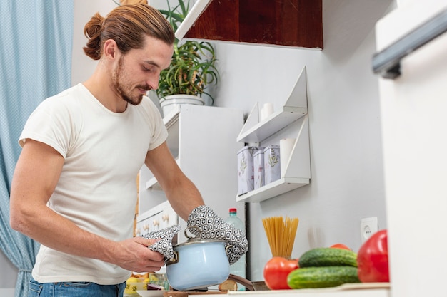 Foto gratuita retrato de hombre guapo sosteniendo una olla