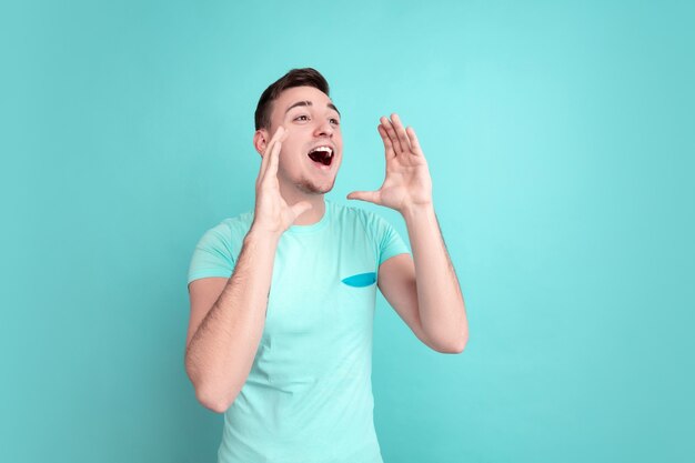 Retrato de hombre joven aislado en la pared azul del estudio