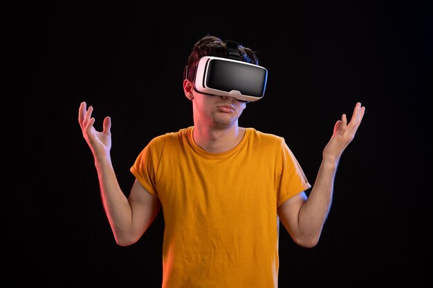 Retrato de hombre joven con auriculares vr en la pared oscura