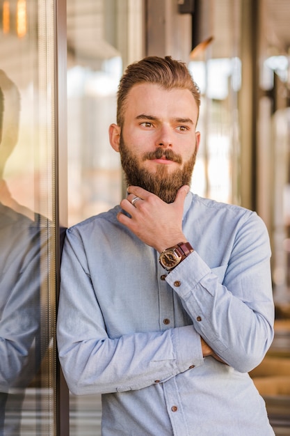 Foto gratuita retrato de un hombre joven barbudo que mira lejos