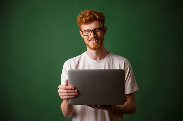 Un retrato de hombre joven de cabeza lectora en camiseta blanca con laptop