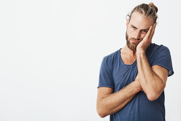 Retrato de hombre joven cansado con elegante peinado y barba