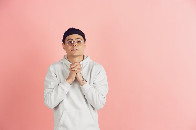 Retrato de hombre joven caucásico con brillantes emociones sobre fondo rosa studio