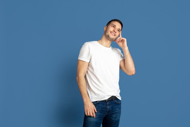 Retrato de hombre joven caucásico en la pared azul