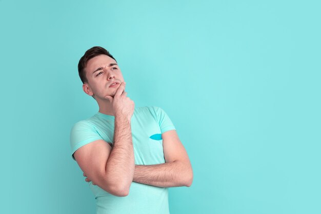 Retrato de hombre joven caucásico en la pared azul