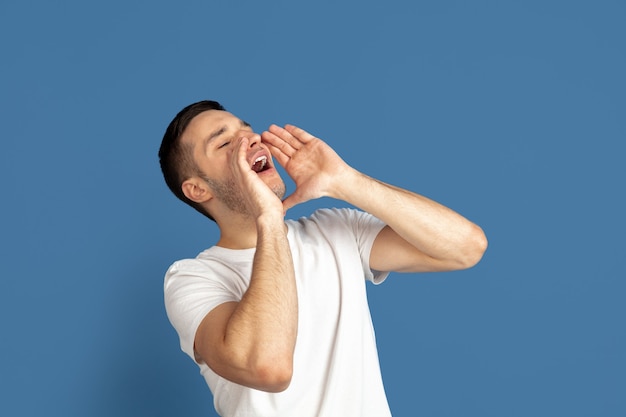 Retrato de hombre joven caucásico sobre fondo azul.