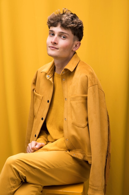 Foto gratuita retrato de un hombre joven en un escenario amarillo