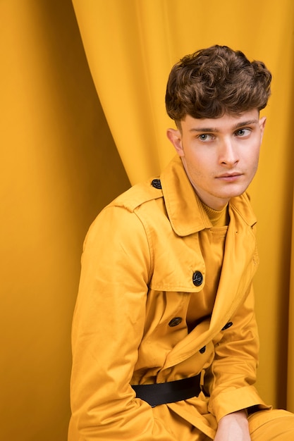 Foto gratuita retrato de un hombre joven en un escenario amarillo