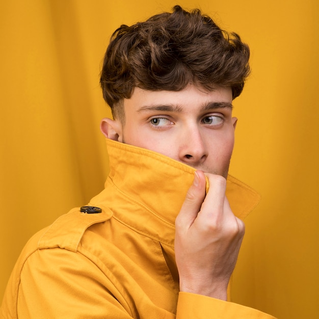 Foto gratuita retrato de un hombre joven en un escenario amarillo