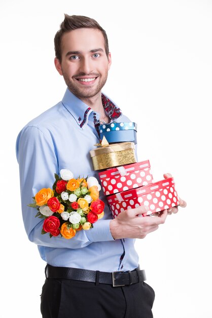 Retrato de hombre joven feliz con flores y un regalo - aislado en blanco.