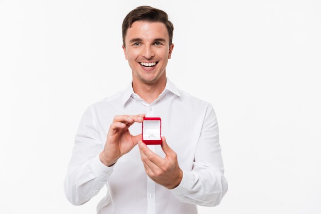 Retrato de hombre joven feliz mostrando caja abierta