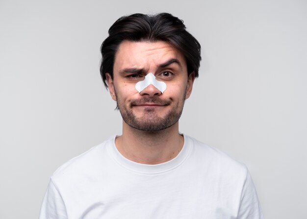 Retrato de un hombre joven con la frente levantada y con un parche en la nariz