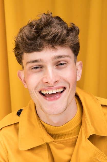 Retrato de hombre joven y guapo en un escenario amarillo