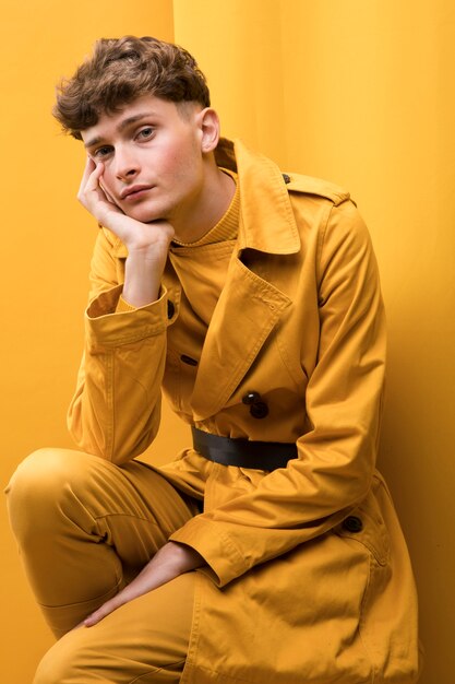 Retrato de hombre joven y guapo en un escenario amarillo