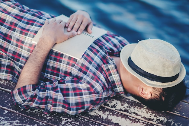 Foto gratuita retrato de hombre joven libro cubierta la somnolencia provoca el sueño.