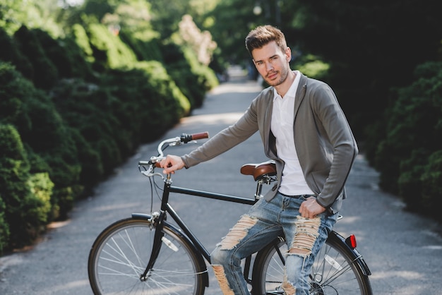 Retrato de hombre joven sentado en bicicleta