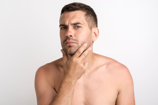 Foto gratuita retrato de hombre joven serio posando y mirando a cámara