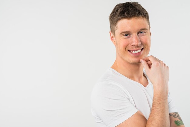 Retrato de un hombre joven sonriente aislado en el contexto blanco