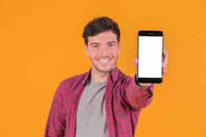 Foto gratuita retrato de un hombre joven sonriente que muestra el teléfono móvil de la pantalla blanca en blanco