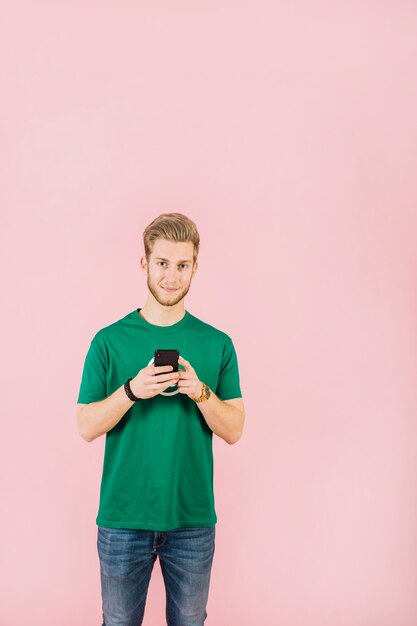 Retrato de un hombre joven con teléfono móvil mirando a cámara