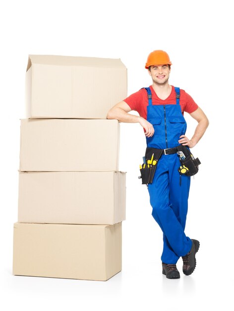 Retrato de hombre joven trabajador de entrega con cajas de papel aislado en blanco